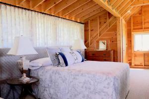 Un dormitorio con una cama con dos lámparas y un techo. en Rustic Chic Maine Cabin @ Diagonair near Sedgwick, Maine, en Brooksville
