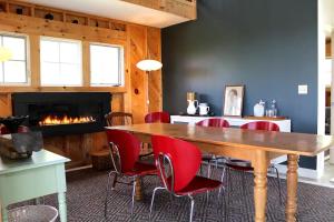 Un comedor con mesa y sillas y chimenea. en Rustic Chic Maine Cabin @ Diagonair near Sedgwick, Maine, en Brooksville