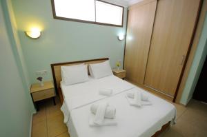 1 dormitorio con 1 cama con sábanas blancas y ventana en Beyaz Konak Evleri en Datca