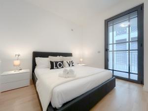 a white bedroom with a large bed and a window at 35 - Casa a due passi Dal mare Terrazza - Wifi - AC in Savona