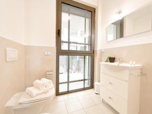 a bathroom with a toilet and a sink and a window at 35 - Casa a due passi Dal mare Terrazza - Wifi - AC in Savona