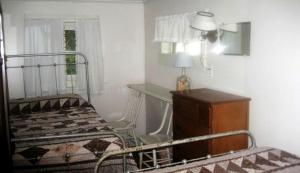 una camera da letto con un letto e una scrivania con una lampada di Inviting Camping Cabin for a Family Getaway in Wells, Vermont a Wells Altre 6 foto