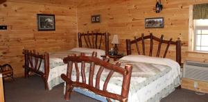 a bedroom with two beds in a log cabin at Luxury Accommodation for Fun Places to Go in Maryland in Flintstone