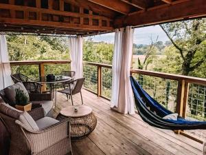 a porch with a hammock and a table and chairs at Magical Tennessee Tiny House with a Rooftop Deck in Maryville +14 photos