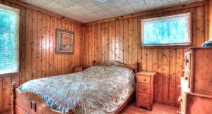 a bedroom with a bed in a wooden room at Deluxe Cabins for Rent near Lake Cumberland in Somerset, Kentucky in Bronston