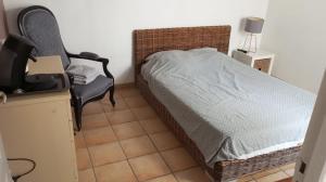 a small bedroom with a bed and a chair at Étage prive avec Chambre, salle de bain, terrasse in Avignon
