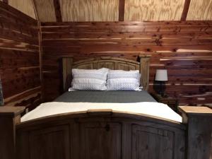 a bedroom with a bed in a log cabin at Comfortable Cabin Rental on a Winery for a Romantic Getaway in Oklahoma in Allen