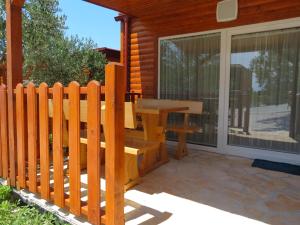 a wooden bench sitting on the porch of a house at Campsite Kaya in Pakoštane