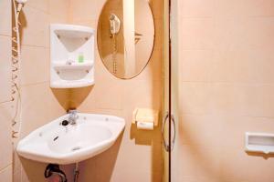 a bathroom with a sink and a mirror at OYO 94799 Siwah Hotel in Banda Aceh +37 photos