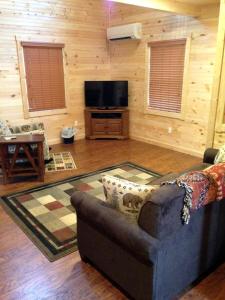a living room with a couch and a flat screen tv at Mammoth Cave Cabin for the Best Holiday in Kentucky in Mammoth Cave