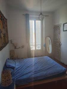 ガルダンヌにあるAppartement 2 chambresの青いベッドと窓のある寝室