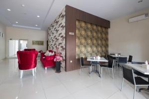 a dining room with red chairs and tables at Capital O 94770 Hotel Astra Novilia in Makassar +17 photos