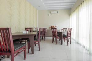 a dining room with a wooden table and chairs at Capital O 94770 Hotel Astra Novilia in Makassar