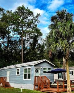 una piccola casa blu con un ponte e un albero di Outstanding Cottage in Dunnellon, Florida a Dunnellon