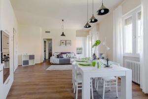 een witte eetkamer met een witte tafel en stoelen bij PeschieraHome Apartments in Peschiera del Garda