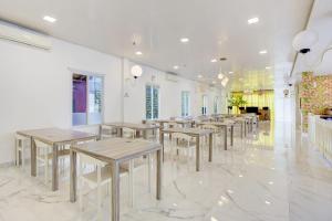 a row of tables and chairs in a room at Capital O 94792 Aleander Hotel in Jakarta