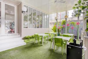 a restaurant with tables and chairs and plants at Capital O 94792 Aleander Hotel in Jakarta