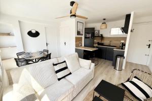 a living room with a white couch and a kitchen at Seaside getaway serenity and comfort in Palavas-les-Flots