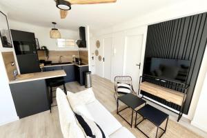 a living room with white furniture and a kitchen at Seaside getaway serenity and comfort in Palavas-les-Flots