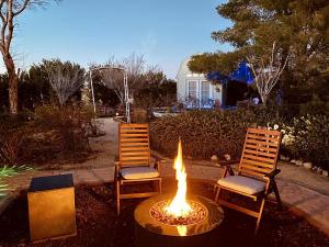 ジョシュア・ツリーにあるBeautiful Vacation Rental with Hot Tub Perfect for Glamping in Joshua Treeの庭の椅子2脚と火炉