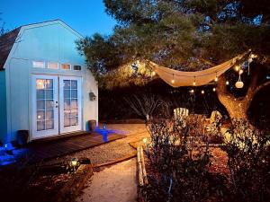 ジョシュア・ツリーにあるBeautiful Vacation Rental with Hot Tub Perfect for Glamping in Joshua Treeの夜の庭にハンモックがある家