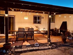 ジョシュア・ツリーにあるBeautiful Vacation Rental with Hot Tub Perfect for Glamping in Joshua Treeのパティオ(テーブル、椅子、照明付)