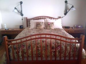 a bed with a wooden headboard and pillows at Bed and Breakfast Cabin for Weekend Getaway near Millbrook, New York in Dover Plains