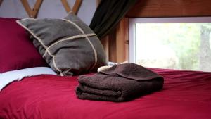 a pile of towels sitting on top of a bed at Nature Escape in an Alaskan Glamping Village for Family Fun in Bear Creek