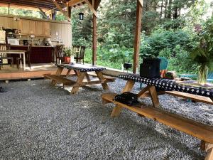 a group of picnic tables in a pavilion with a kitchen at Nature Escape in an Alaskan Glamping Village for Family Fun in Bear Creek