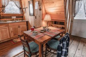 a dining room with a wooden table and chairs at Cozy Log Cabin with an Indoor Fireplace Located on 70 Forested Acres in Leicester, Vermont in Leicester