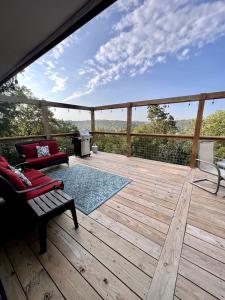 a large wooden deck with a bench and a grill at Cozy Cabin Rental near Table Rock Lake in the Ozark Mountains, Missouri in Hollister