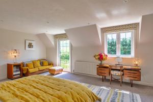 1 dormitorio con cama amarilla y sofá en Finest Retreats - Grassyards House, en Skelmorlie