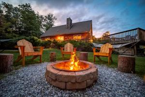 a fire pit in front of a house at Incredible New York Cabin with a Spa and Movie Theater in Livingston Manor +82 photos