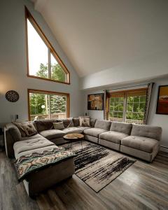 a large living room with a large couch and windows at Incredible New York Cabin with a Spa and Movie Theater in Livingston Manor