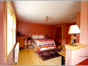 a bedroom with a bed and a lamp and a window at Idyllic Cottage Rental near Mount Mansfield State Forest, Vermont in Hardwick