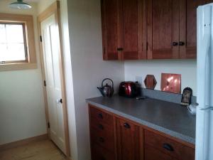 a kitchen with wooden cabinets and a counter top at Idyllic Cottage Rental near Mount Mansfield State Forest, Vermont in Hardwick