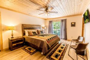 a bedroom with a bed and a ceiling fan at Incredible Mountain Cabin with Private Creek and Hot Tub Allowing Outstanding Views in Bryson City in Franklin Grove