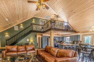 a living room with a couch and a staircase at Incredible Mountain Cabin with Private Creek and Hot Tub Allowing Outstanding Views in Bryson City in Franklin Grove