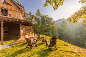 a group of chairs and a table on a hill at Incredible Mountain Cabin with Private Creek and Hot Tub Allowing Outstanding Views in Bryson City in Franklin Grove