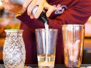 a person is pouring a drink into a glass at Mercure Nice Centre Notre Dame in Nice