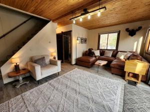 un salon avec un canapé, des chaises et une table dans l'établissement Secluded Luxury Cabin with Hot Tub on 10 Private Acres near Trails in Reed City, Michigan, à Idlewild 16 autres photos