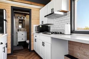 a kitchen with white cabinets and a sink at Joshua Tree Tiny Home for Unique Getaways, California in Hidden River