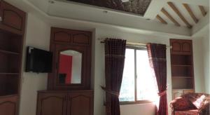 a living room with a tv and a window at Al Waqas Hotel in Dargai