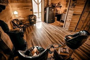 ein Wohnzimmer mit Ledermöbeln in einer Blockhütte in der Unterkunft Luxury Cabin for Two with Beautiful River Views near Knoxville in Greeneville