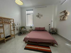 a bedroom with a bed in a white room at Nhi Homestay Rạch Giá in Rach Gia +5 photos