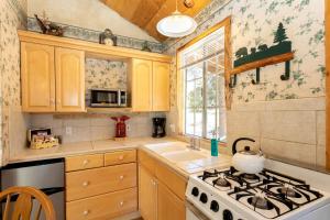 a kitchen with wooden cabinets and a stove top oven at Romantic Log Cabin in the San Bernardino National Forest of California in Angelus Oaks