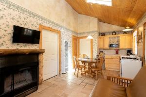 a kitchen with a living room with a fireplace and a table at Romantic Log Cabin in the San Bernardino National Forest of California in Angelus Oaks