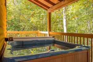 a hot tub on a porch of a cabin at Secluded Cabin with Hot-tub and Fire Pit in Cleveland, Georgia in Kinseytown