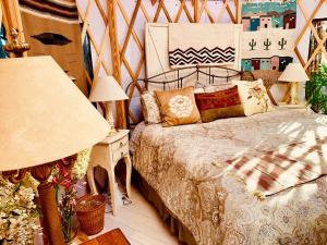 a bedroom with a bed and a table with lamps at Charming Yurt in the Cibola National Forest near Albuquerque, New Mexico in Tijeras +13 photos