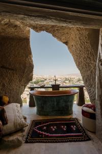 ein Badezimmer mit einer Badewanne in einer Steinhöhle in der Unterkunft Cappadocia Cave Suites Adult Only in Goreme